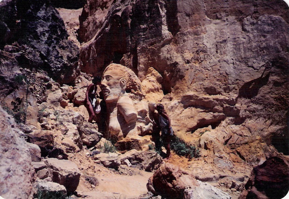 Escultura de cabeça na areia entre a Primeira e Segunda Praia, 1987